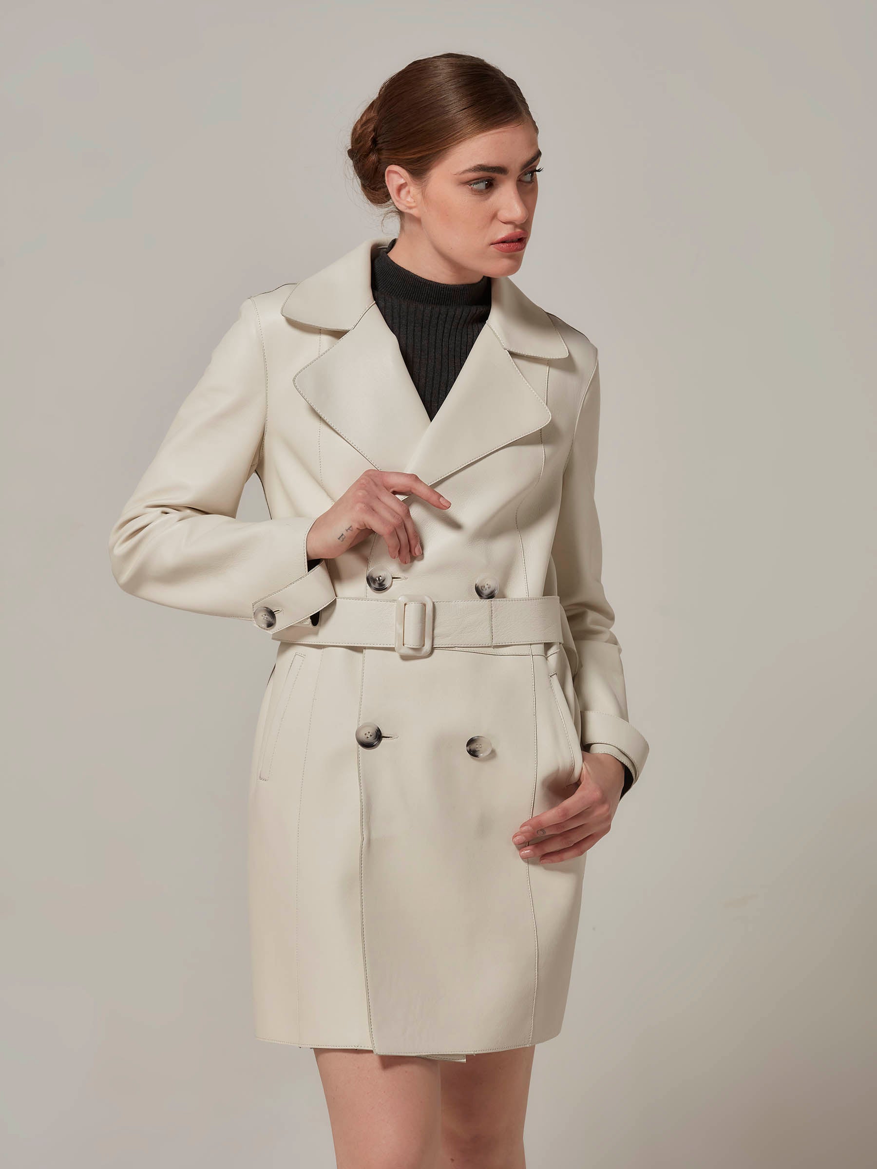 woman posing in white leather trench coat front view